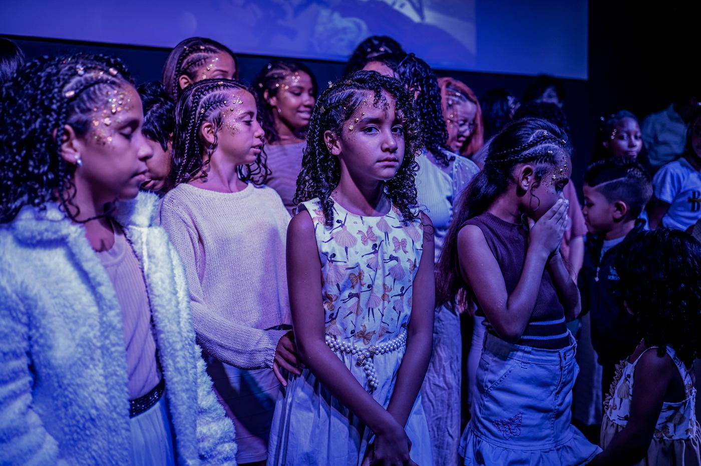 Crianças em momento de reverência no palco